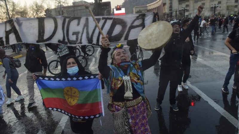 Un manifestante sostiene una bandera mapuche durante una protesta contra el manejo del gobierno de la pandemia del coronavirus.
