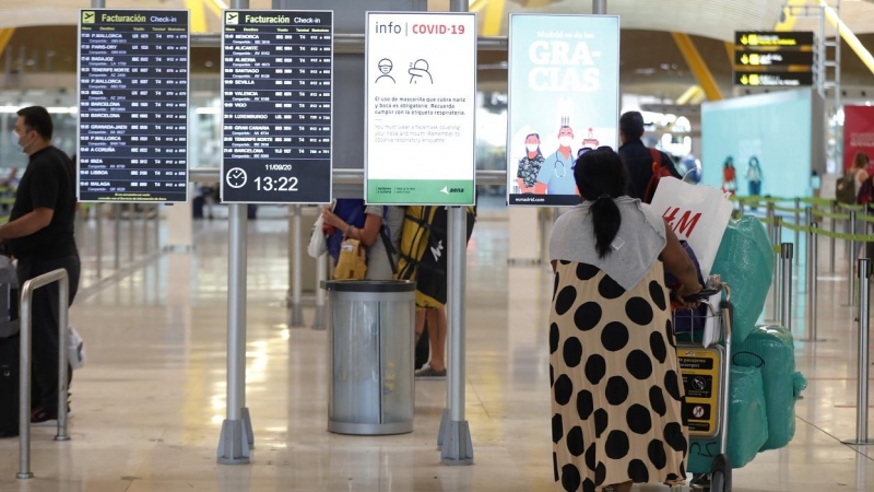 Pasajeros cerca de páneles informativos en la terminal T4 del aeropuerto Adolfo Suárez Madrid-Barajas. E.P./Jesús Hellín