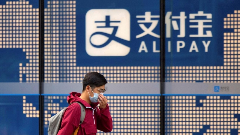 Un hombre pasa por delante de un cartel del sistea de pago electrónico Alipay, de Ant Group, en un edificio en Shanghai. EFE/EPA/ALEX PLAVEVSKI
