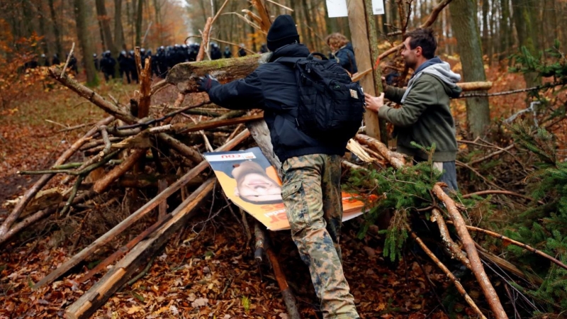Los manifestantes levantan una barricada de madera después de que los oficiales de policía la desmantelaron durante una protesta contra la extensión de la autopista A49, en un bosque cerca de Stadtallendorf, Alemania.
