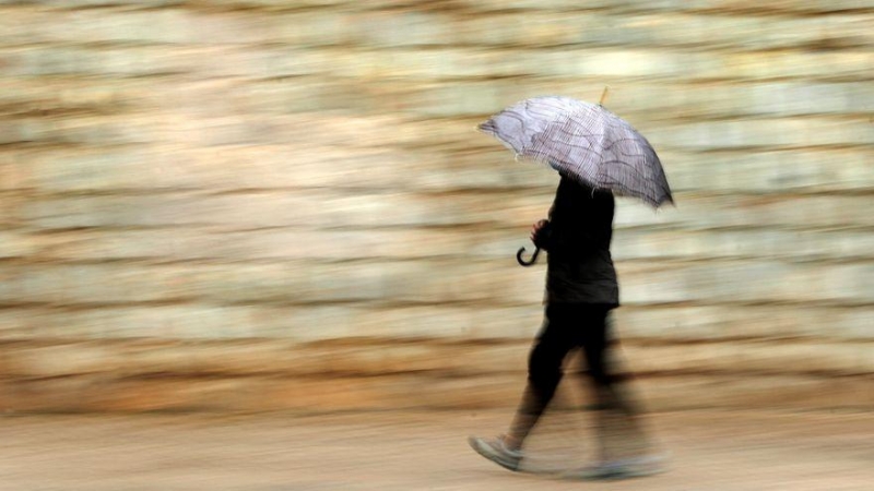 Una persona se protege de la lluvia con paraguas.