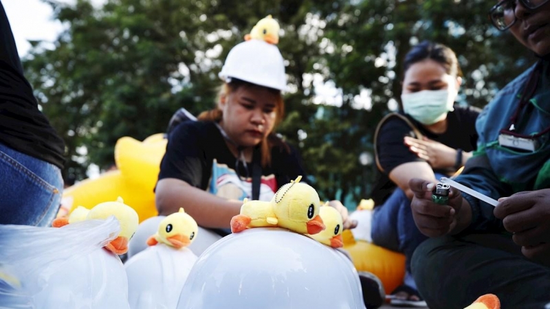 Los manifestantes pegan patitos de goma en cascos para distribuirlos entre otros manifestantes antes de una protesta antigubernamental que pide la reforma de la monarquía en Tailandia.
