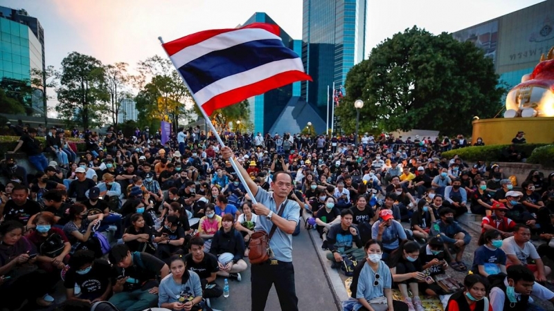 Un manifestante antigubernamental ondea una gran bandera nacional tailandesa durante una protesta que pide la reforma de la monarquía.