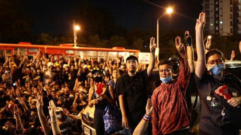 Los manifestantes a favor de la democracia hacen el saludo de tres dedos mientras participan en una manifestación contra el gobierno frente a la sede del Siam Commercial Bank en Bangkok.