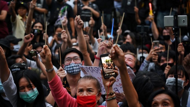 Los manifestantes sostienen varitas en el aire durante un mitin antigubernamental con temática de Harry Potter en el Monumento a la Democracia en Bangkok.