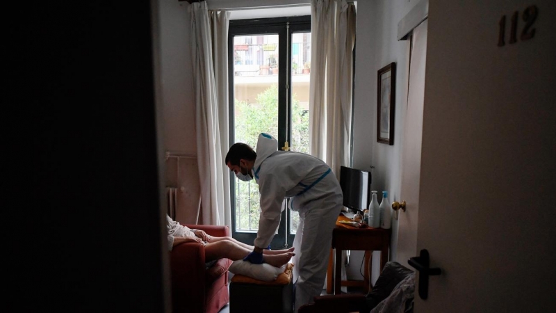 Un terapeuta atiende a una mujer en una residencia de Madrid.