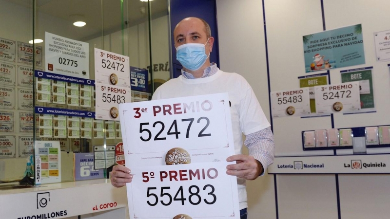 Luis Vázquez, propietario de la administración número 2 de Arroyo de la Encomienda (Valladolid), muestra los números 52472 y 55483, tercer y quinto premio de la lotería de Navidad.