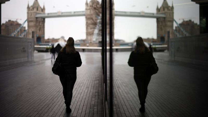 Una mujer camina cerca del Tower Bridge en Londres, Reino Unido