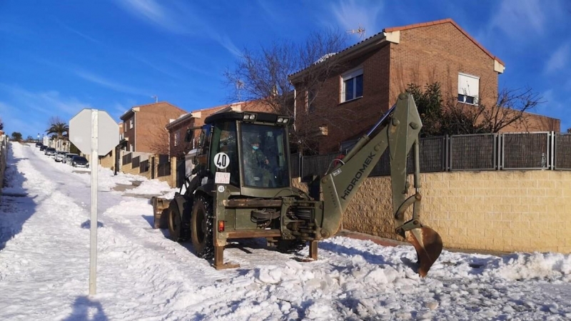 Una excavadora de la Brigada Extremadura XI del Ejército ayuda en la retirada de la nieve y el hielo de una calle de Guadalajara este jueves, tras el paso del temporal Filomena.