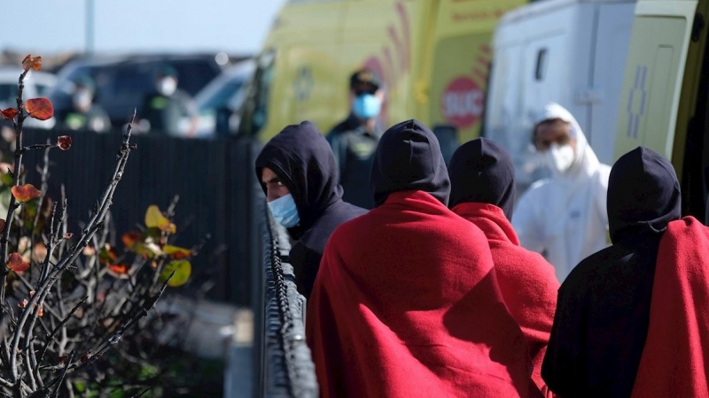 Un grupo de migrantes es atendido tras conseguir llegar en patera al muelle de Caleta de Fuste, en el municipio de Antigua (Fuerteventura).