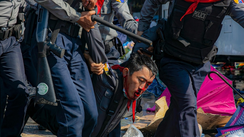 Agentes de policía llevan a un manifestante herido después de que la policía antidisturbios reprimió a los manifestantes durante una manifestación contra el golpe de estado militar que depuso a la Consejera de Estado de Myanmar de Myanmar, Aung San Suu Ky