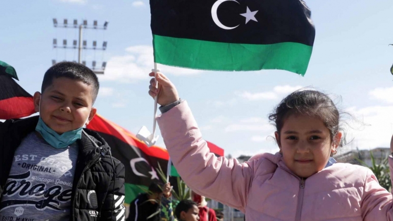 Niños libios sosteniendo banderas libias un día antes de las conmemoraciones del décimo aniversario del levantamiento contra el exlíder Moamer Kadhafi, en Trípoli, Libia, el 16 de febrero de 2021.