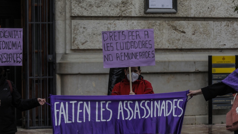 Una participante sostiene un cartel donde se puede leer 'Faltan las asesinadas' en la concentración convocada por la Assemblea Feminista en la plaza del Ayuntamiento de Valencia con motivo del 8-M, Día Internacional de la Mujer,