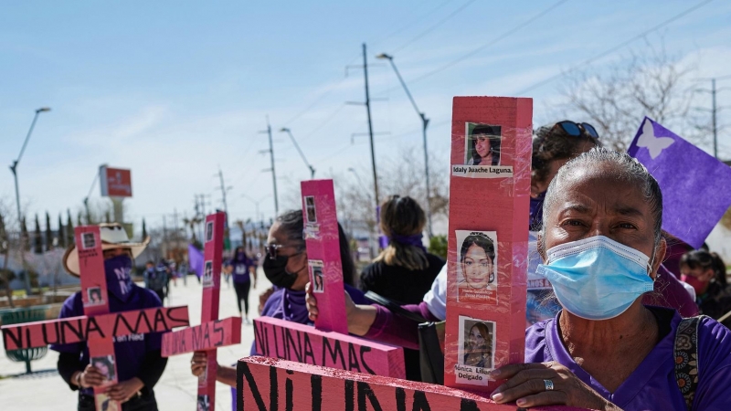 Mujeres sostienen cruces en la que se lee: 'Ni una más' en Ciudad Juarez, México