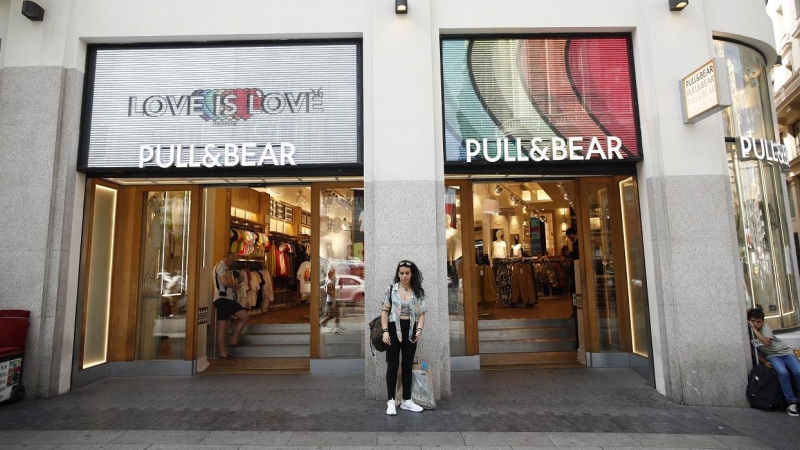 Una joven en la entrada de una de las tiendas de Pull&Bear, una de las marcas de Inditex, en la Gran Vía de Madrid. E.P./Eduardo Parra