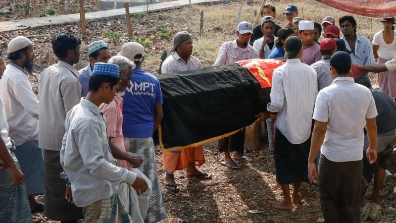 Varias personas asisten al funeral de una persona asesinada en las protestas contra el golpe militar, en Myanmar. - Reuters