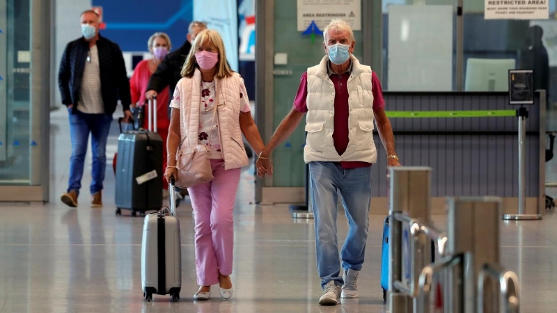 Una parejas de turistas, procedentes de un vuelo del Reino Unido, en la terminal del aeropuerto de Malaga-Costa. REUTERS/Jon Nazca