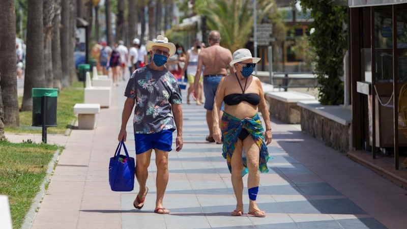 Una pareja anda por el paseo marítimo de Playamar en Málaga.