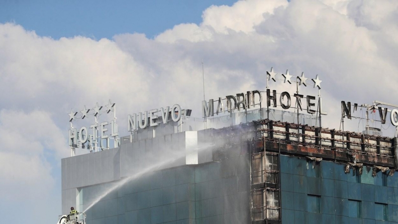 Bomberos extinguen las llamas tras un aparatoso incendio en la fachada exterior del Hotel Nuevo Madrid, situado junto a la zona norte de la M-30 en Madrid, este jueves.