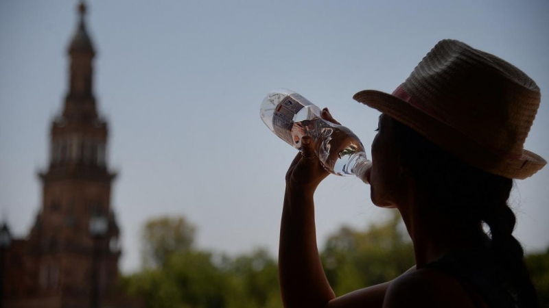 Una mujer bebe agua en Sevilla durante la ola de calor de junio de 2019.
