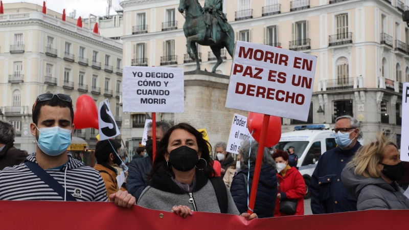 Una mujer con un cartel en el que se lee: `Morir en paz es un derecho´ durante una concentración de Derecho a Morir Dignamente en la Puerta del Sol, en Madrid (España), a 18 de marzo de 2021.