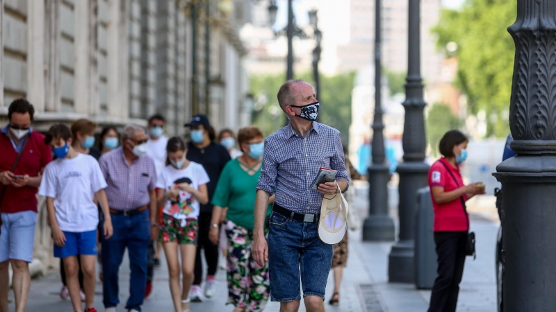 Varias personas pasean con mascarilla durante el último día de la obligatoriedad de mascarillas en exteriores, este viernes en Madrid. - EUROPA PRESS