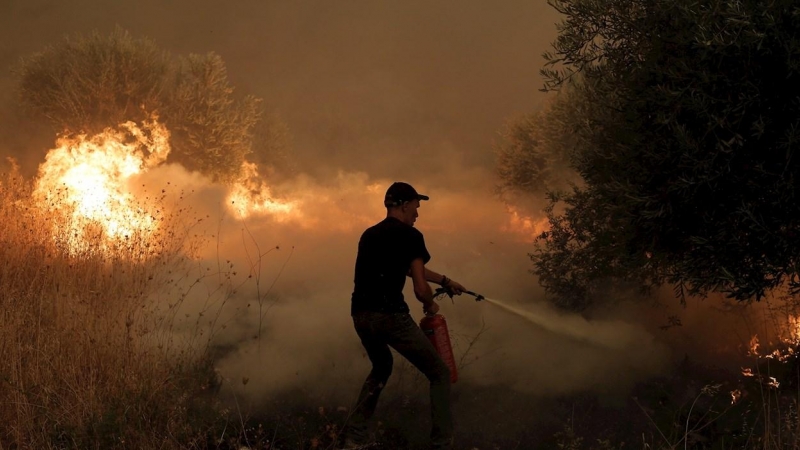 Un residente local lucha contra las llamas durante un incendio forestal en la aldea de Pefki en la isla Evia