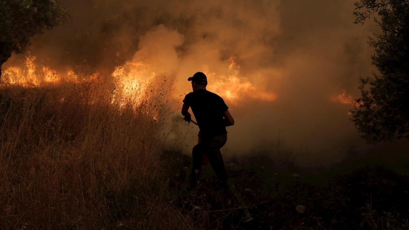 Un voluntario local en labores de extinción de un incendio en la localidad de Istiaia, en la isla griega de Eubea.