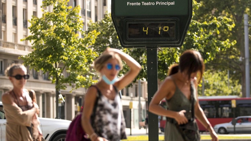 Varias personas pasean por el centro de Zaragoza en plena ola de calor marcando los termómetros hasta 41º.