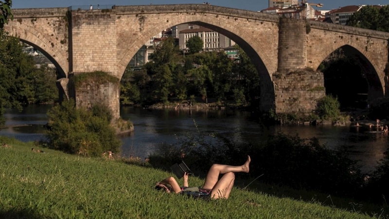 Una mujer disfruta este martes de las altas temperaturas en el entorno del río Miño