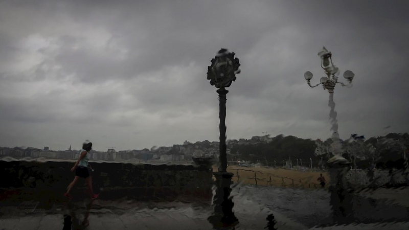Una mujer camina bajo la lluvia en San Sebastián.