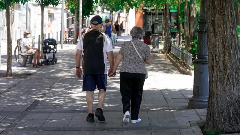 Una pareja de ancianos camina por la calle cogida de la mano, en Madrid. E.P./A. Pérez Meca