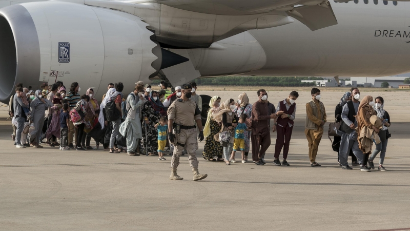 Varias personas, entre ellas niños llegan a la base aérea de Torrejón de Ardoz.