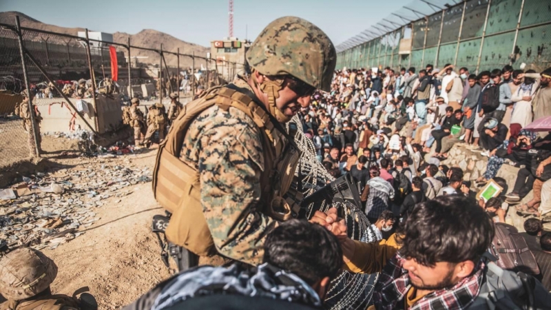 Un soldado de EEUU atiende a civiles afganos en el plan de evacuación en el aeropuerto de Kabul.