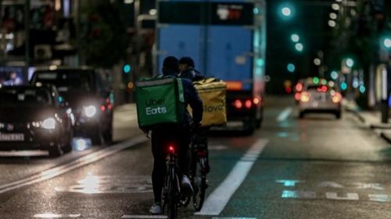 Foto de archivo. Un rider de Uber Eats y de Glovo circulan por las calles de Madrid.