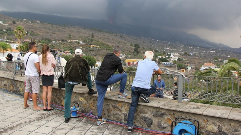 Lugareños y turistas observan la erupción del volcán desde el mirador de Tajuya, donde trabajan también la mayoría de medios de comunicación.