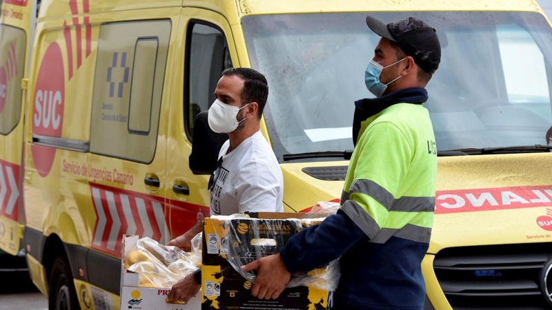 Dos voluntarios llevan al pabellón deportivo de Los Llanos de Aridane comida donada por empresa de La Palma para las familias desplazadas de sus viviendas por la erupción del volcán.