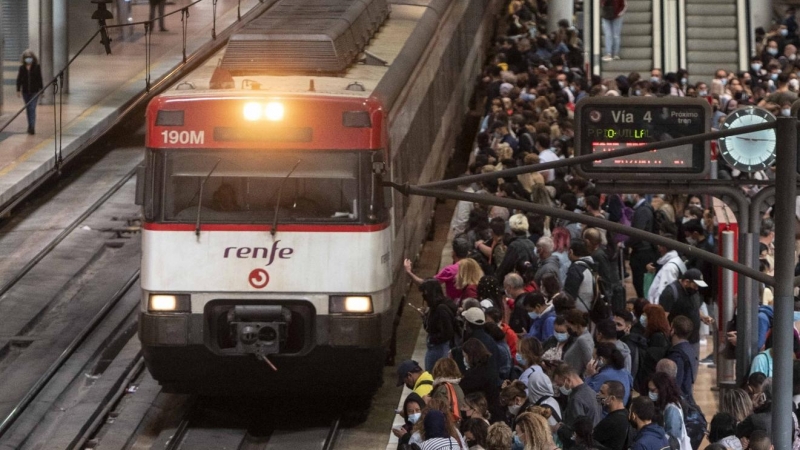 Un gran número de pasajeros espera la llegada de un tren en la estación de Madrid.