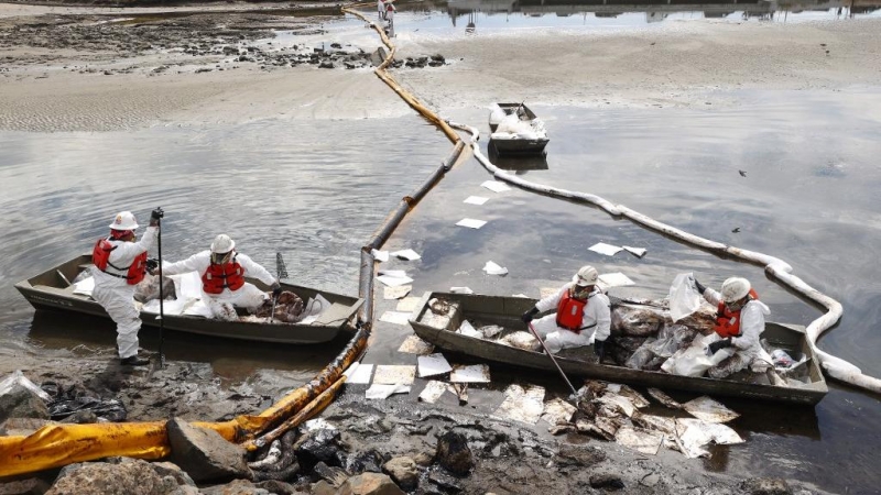 Un grupo de trabajadores limpian el petróleo vertido en las costas de Huntington, en el sur de California.