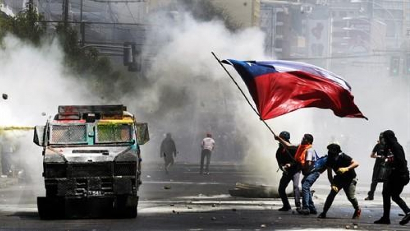 Manifestantes ondean una bandera chilena durante una protesta contra el Gobierno en las manifestaciones del 'estallido social' en el 30 de octubre de 2019.