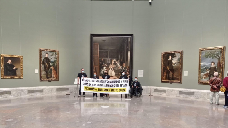 El grupo de personas con un cartel junto al cuadro de Las Meninas, en el Museo del Prado.