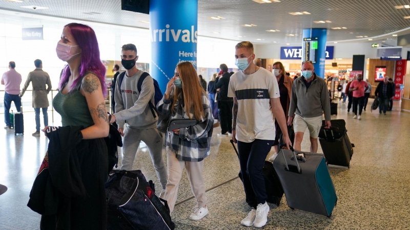 Viajeros con mascarillas en un aeropuerto de Reino Unido.