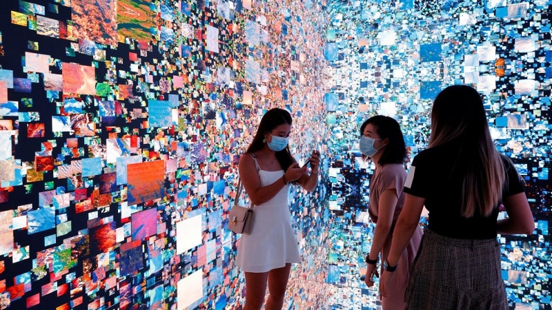 Varias personas frente a una instalación de arte inmersiva en Hog Kong titulada 'Machine Hallucinations - Space: Metaverse' del artista Refik Anadol, que se convertirá en NFT y se subastará en Sotheby's. REUTERS / Tyrone Siu