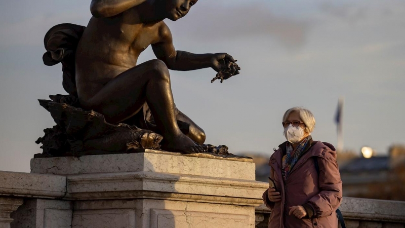 Una mujer con mascarilla protectora camina por el Puente Alexandre III este jueves en París.