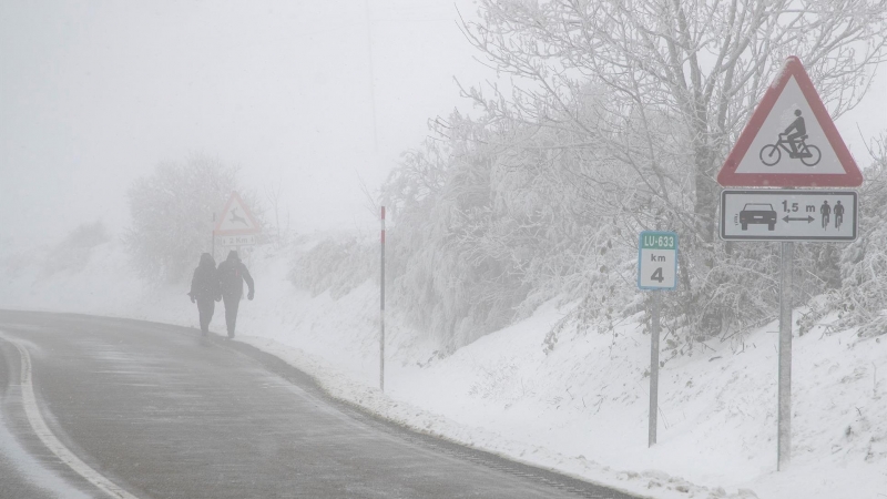 Dos personas caminan entre la nieve este domingo en O Cebreiro.