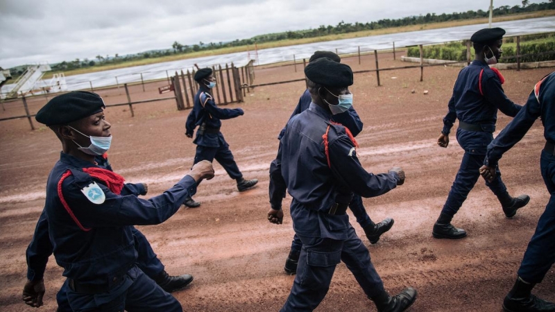 Agentes de la Policía congoleña desfilan en la pista del aeropuerto de Gbadolite, en el norte de la República Democrática del Congo, para la repatriación de refugiados centroafricanos a Bangui, el 15 de noviembre de 2021.