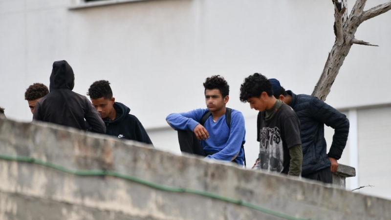 Varios menores migrantes, en el tejado de una nave industrial, a 27 de agosto de 2021, en Ceuta.
