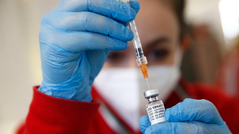 Un trabajador de la salud utiliza una jeringa para extraer una dosis de la vacuna Pfizer / BioNTech COVID-19.