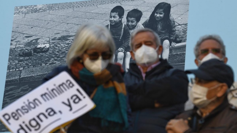Un grupo de personas con un cartel durante una manifestación que reclama el blindaje de las pensiones en la Constitución, a 13 de noviembre de 2021, en Madrid.