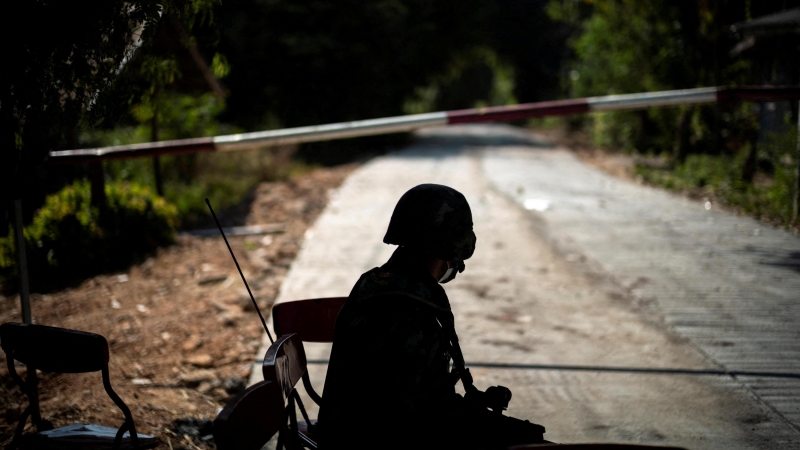 24/12/2021 Un soldado tailandés se sienta frente a una carretera bloqueada que conduce a la frontera entre Tailandia y Myanmar, donde aún continúan los combates